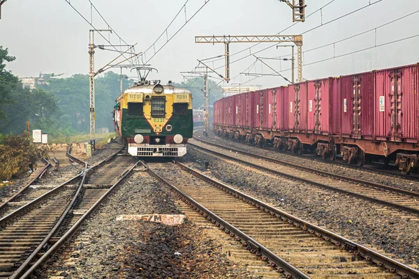 Tren de pasajeros local de los Ferrocarriles de la India a punto de entrar en una estación en Calcuta con los viajeros . — Foto de Stock