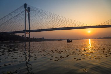 Nehir Hooghly üzerinde günbatımı bir tekne görüldüğü gibi Vidyasagar Setu Köprüsü yakınında.