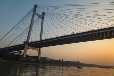 Vidyasagar Setu (köprü) olarak alacakaranlık nehirde Hooghly bir tekne görüldüğü gibi. Kolkata, Hindistan.