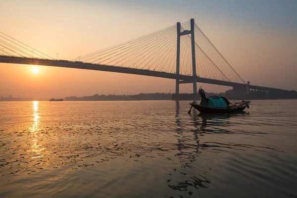 Holzboot auf dem Fluss in der Dämmerung nahe der Vidyasagar-Brücke (setu), Kolkata, Indien. — Stockfoto