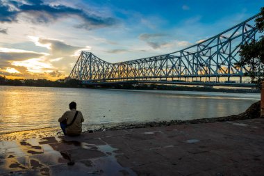 Günbatımı nehir Ganj olarak da bilinen Hooghly Nehri Kalküta, Hindistan, Howrah köprüde üzerinde.