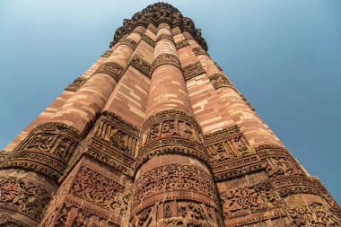 Qutub Minar yakın çekim kırmızı kumtaşı oymalar ayağı duvar ile. 