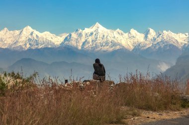 Genç turist kız, Munsiyari Uttarakhand Hindistan 'daki görkemli Panchuli Himalaya dağ sırasının tadını çıkarıyor..