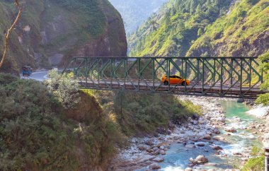 Uttarakhand Hindistan 'daki dağ köprüsü ve dağ sırasının bulunduğu dağ vadisi manzarası..