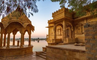 Antik tapınaklar ve Rajput mimarisi Gadi Sagar Gölü Jaisalmer, Rajasthan Hindistan 'da gün doğumunda.
