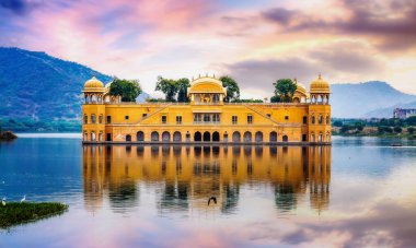 Jal Mahal historic water palace in the midst of a lake with scenic landscape at Jaipur Rajasthan at sunset with vibrant moody sky clipart