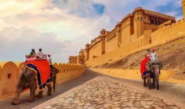 Jaipur, Rajasthan, Hindistan, 11 Aralık 2017: Gündoğumunda tarihi Amer Kalesi Jaipur 'da turistlerle süslenmiş filler