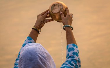 Hindu kadın, Varanasi Ghat Hindistan 'da sabah ayininin bir parçası olarak Ganj Nehri' ne su sunuyor..