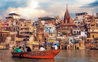 Varanasi, Hindistan, 13 Ekim 2017: Turistler antik mimariye sahip tarihi Varanasi şehrine bakan Ganj Nehri üzerinde tekne turunun keyfini çıkarıyorlar.