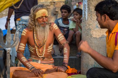 Varanasi, Hindistan, 13 Ekim 2017: Hindu sadhu baba Hindistan 'ın Varanasi kentindeki Ganj nehri ghatında genç bir adama vaaz veriyor..
