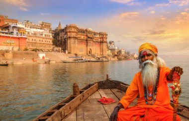 Sadhu baba, tarihi Varanasi şehrine bakan ahşap bir teknede ve Ganj nehri ghatları, Hindistan.
