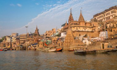 Ganj nehri ghatı boyunca antik mimari binaları ve tapınakları olan tarihi Varanasi şehri bir tekneden görülüyor..