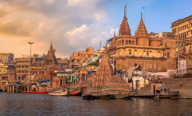 Tarihi Varanasi şehir mimarisi ve Ganj nehri ghat antik tapınaklar ve binalar ile gün batımında.
