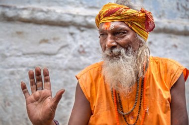 Varanasi, Hindistan, 12 Ekim 2017: Varanasi sadhu baba bir ara sokakta poz vererek Ganj Nehri 'nin yanındaki ghat' a dua elini kaldırdı.