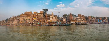 Varanasi şehir mimarisinin panoramik manzarası ve Ganj nehri nehir ghatları nehirdeki bir tekneden izleniyor.. 