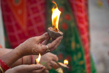 Hintli Hintli kadın el yapımı el yapımı kil bir lambayı Ganj nehrinde kurban etmek için kutsal ateşle tutuyordu. Varanasi Hindistan 'daki bir ayin için..