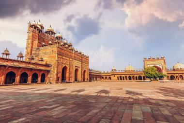 Fatehpur Sikri Agra ortaçağ mimarisi. Buland Darwaza olarak bilinen dev kumtaşı geçidi. Babür İmparatoru Akbar tarafından Hindistan 'ın Agra kentinde inşa edilmiş.