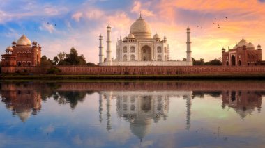 Taj Mahal tarihi beyaz mermer heykeli gün batımında Agra, Hindistan 'daki Yamuna nehrinde su yansıması ile