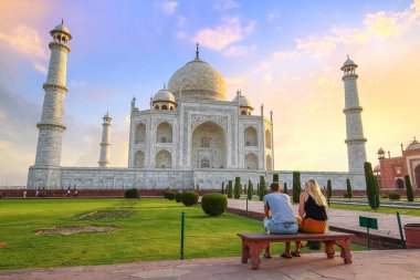 Taj Mahal beyaz mermer antik anıt güneş doğarken Agra Hindistan 'da romantik bir anın tadını çıkaran turist çiftle birlikte.