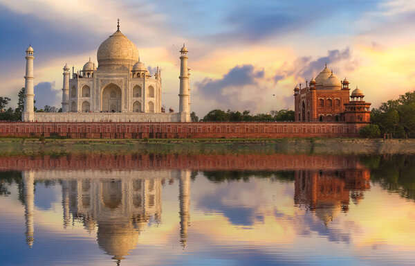 Taj Mahal Agra India white marble medieval monument at sunset with water reflection on river Yamuna