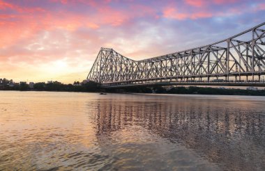 Howrah bridge at Kolkata on river Hooghly with moody sunset sky.