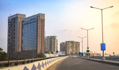 Gündoğumunda yüksek binalı şehir manzarası Kolkata, Hindistan 'daki bir köprüden izleniyor..