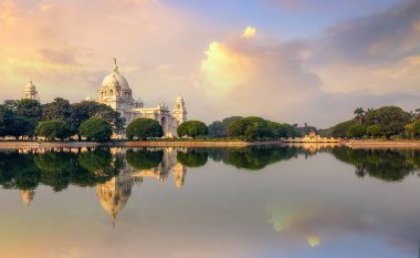 Victoria Memorial 'da, gün doğumunda bitişik göl ve hüzünlü gökyüzü Kolkata Hindistan' da..
