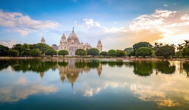 Victoria Anıtı tarihi koloni mimari binası ve gün batımında Kolkata Hindistan 'da göl.
