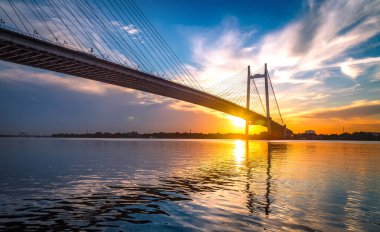 Vidyasagar Setu olarak bilinen asma köprü Prinseps Ghat Kolkata Hindistan 'dan gün batımında Ganj Nehri üzerine inşa edilmiştir. 