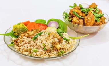 Yeşil sebzelerle süslenmiş kızarmış pirinç ve baharatlı tavuk yemeği. Beyaz arka planda izole edilmiş popüler Bengali Hint mutfağı..