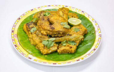 Muz yaprağında limon ve kişniş ile servis edilen balık masala. Rohu balığı popüler bir Bengali Hint yemeğidir..