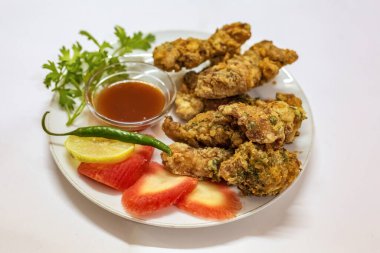 Bol yağda kızartılmış baharatlı tavuk pakora domates soslu ve dilimlenmiş havuç limonlu kişniş yapraklı yeşil biberli. Popüler bir Hint başlangıç yemeği..