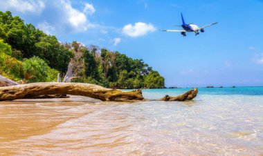 Yolcu uçakları Andaman, Hindistan 'daki Neşeli Şamandıra adası sahili üzerinde alçaktan uçuyor..