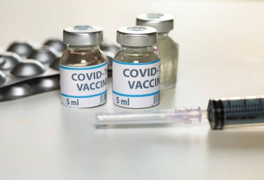 Coronavirus önleyici ilaçlar aşı şişeleri ve şırınga ile seçici odak noktası