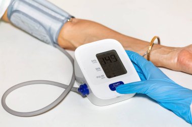 Doktor kan basıncını ve kalp atışlarını ölçmek için taşınabilir kan basıncı izleme cihazı kullanıyor.
