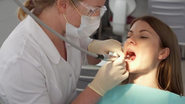 Zubař léčení zubů žena pacientovi v klinice. Profesionální lékařka při práci. Zubní prohlídka