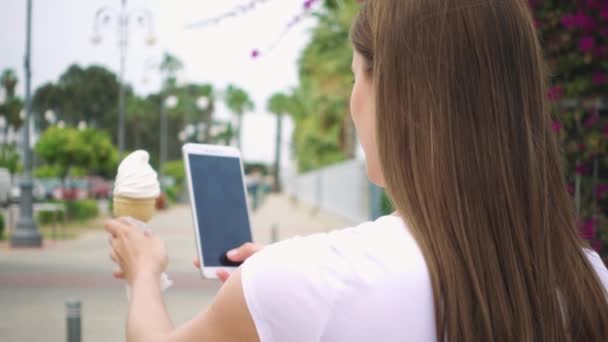 Žena pořizování Foto kužel zmrzliny. Teenagery fotografování zmrzliny na fotoaparát telefonu ve zpomaleném záběru