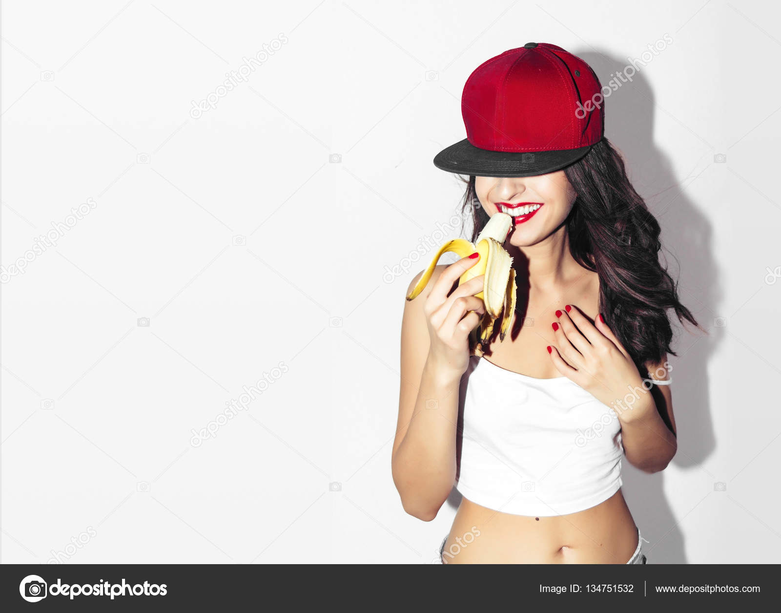 Young pretty teen girl with wearing stylish hipster outfit, and eating banana. Party Oral Sex Blow Job Concept