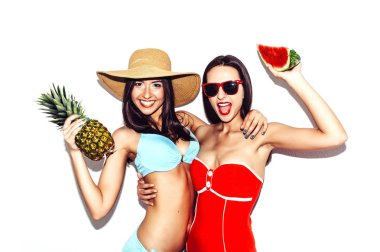 Tatil. Yaz seyahat. İki güzel seksi esmer kadın karpuz ve ananas gülmek eğlenmek bikini ile açık plajda gülümse. Palmiye ağacı kopya alanı için metin ile ahşap arka plan