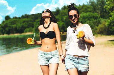 İki harika trendy hipster ikiz kız tropik bir adada tatil zevk Plajı'nda kokteyller ile mükemmel bronzlaşmış vücudu, sağlıklı cilt, seksi şık rahat kıyafet, bikini, güneş gözlüklü esmer İkizler