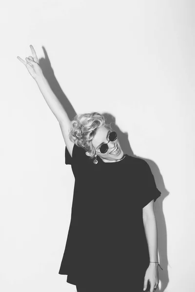 Stilvolle Mode sexy blonde Bad Girl in einem schwarzen T-Shirt und Rock-Sonnenbrille. gefährliche felsige emotionale Frau. Schwarz-weiß getönt. weißer Hintergrund, nicht isoliert — Stockfoto
