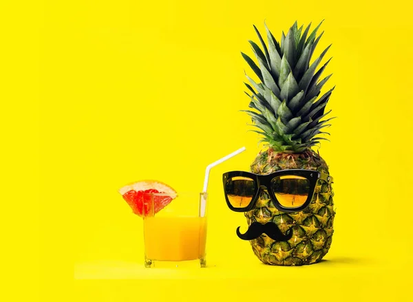 Sarı arka plan üzerinde eğlenceli moda ananas ile güneş gözlüğü ve taze tropikal meyve ile kokteyl bıyıklı. Tatil ve seyahat kavramı.