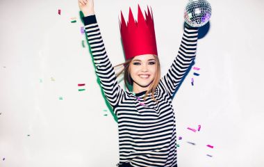 Arka plan kutluyor brightful olay parti kız renkli sahne ışıkları ve beyaz üzerinde gülümseyen konfeti, elbise ve kırmızı taç giyer elimden. Köpüklü konfeti, eğlenceli, dans, gülmek, disko topu sahip.