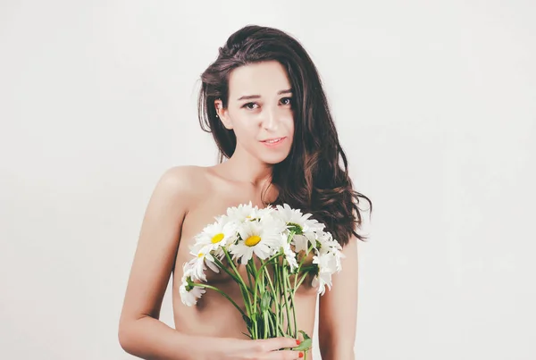 Ніжний милий красивий літній молодий дівчина з топлес тіло ідеальна шкіра. тримає квіти ромашки. білий фон — стокове фото
