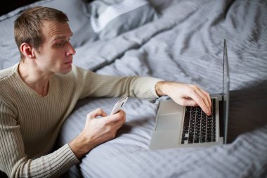 Genç bir adam üzerinde laptop klavye tuşları presler.