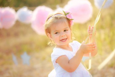 Mutlu bebek doğum günü kutlaması üzerinde. Karşı beyaz elbiseli bir kız gülümsüyor.