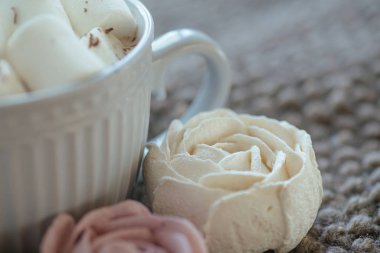 Marshmallow looks like rose close-up. cup with small marshmallows sprinkled with grated chocolate on cotton knitted napkin. Homemade pink marshmallow. Sweets from natural products without GMOs.