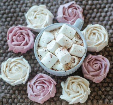 Homemade marshmallows around grey cup with cocoa or hot chocolate over top. pink marshmallow like rose close-up. Present for woman on valentines day. Sweets from natural products without GMOs.