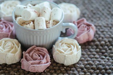 Homemade marshmallows around grey cup with cocoa or hot chocolate over top. pink marshmallow like rose close-up. Present for woman on valentines day. Sweets from natural products without GMOs.