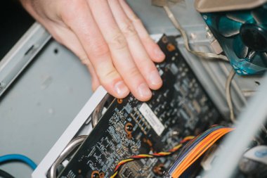 Profesyonel adam içeride bilgisayar onarıp monte ediyor. Erkek el bilgisayara grafik kartı yerleştirir. Tanı hizmeti ve onarım bilgisayarı, tablet ve dizüstü bilgisayar kavramı.